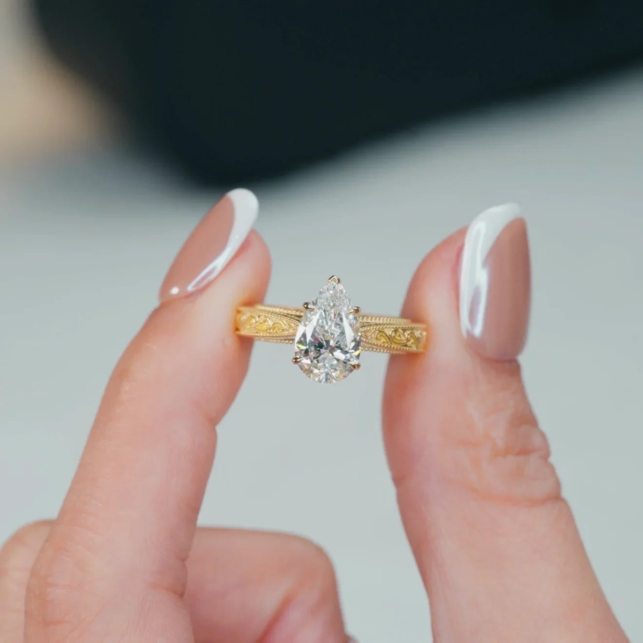 Pear cut lab-grown diamond engagement ring in yellow gold with intricate band details