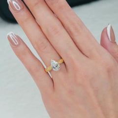 Pear-shaped lab-grown diamond ring in yellow gold on woman's hand