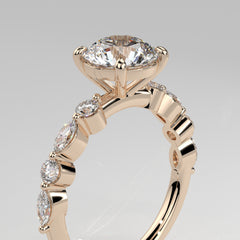 Orbis Round lab-grown diamond solitaire ring with marquise and round side stones in 18K rose gold, angled close-up of four-prong setting