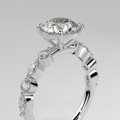 Orbis Round lab-grown diamond solitaire ring with marquise and round side stones in 18K white gold, angled close-up of four-prong setting