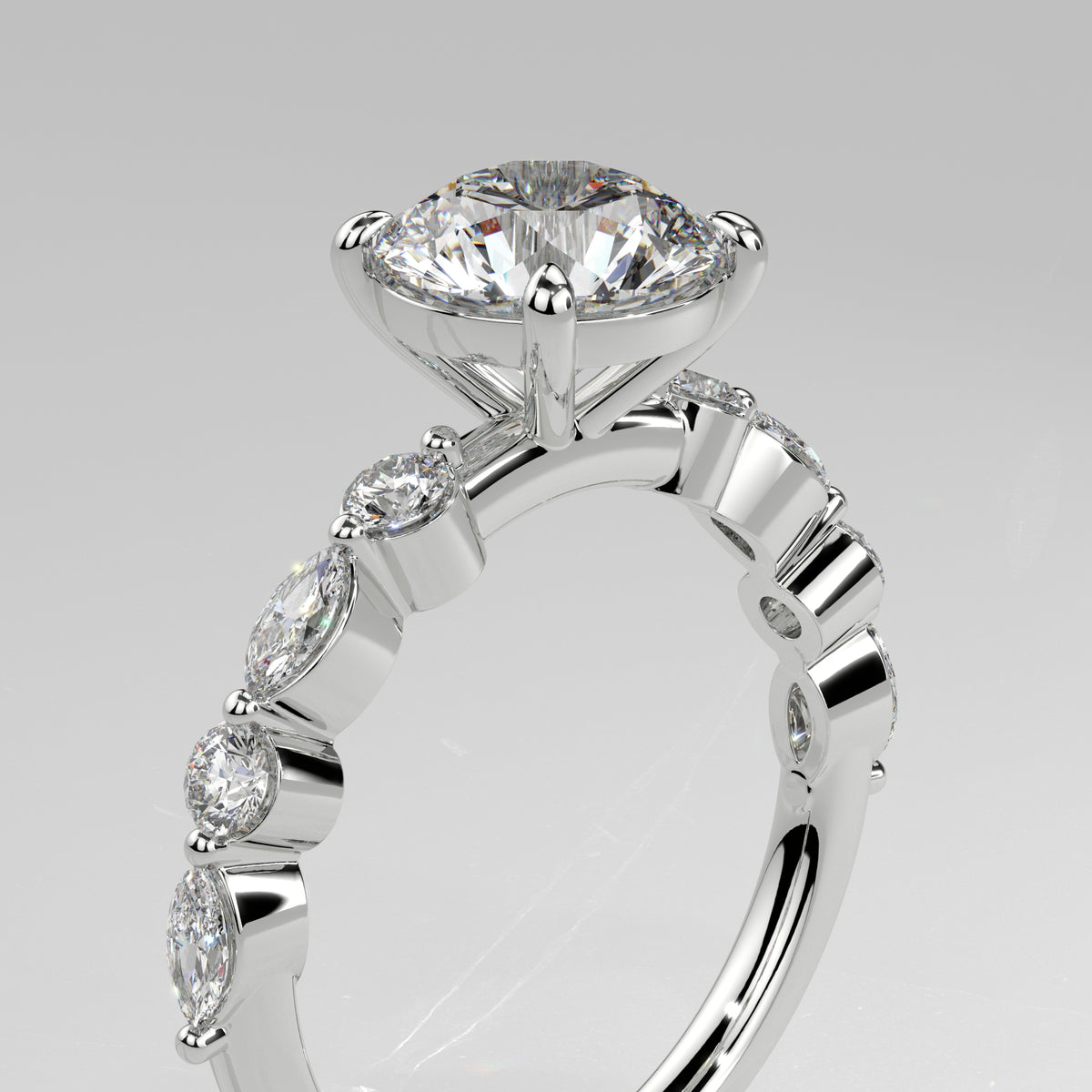Orbis Round lab-grown diamond solitaire ring with marquise and round side stones in 18K white gold, angled close-up of four-prong setting