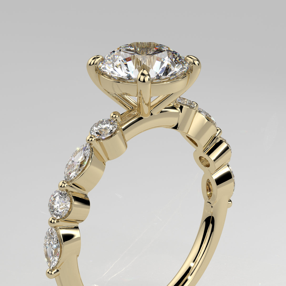 Orbis Round lab-grown diamond solitaire ring with marquise and round side stones in 18K yellow gold, angled close-up of four-prong setting
